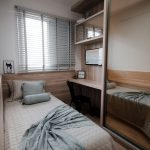 Gezellige minimalistische slaapkamer met eenpersoonsbed en kleine werkplek