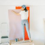Vrouw brengt behang aan op een muur
