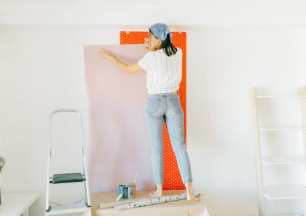 Vrouw brengt behang aan op een muur