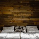 Slaapkamer met houten hoofdeinde en sfeerverlichting