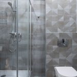 Hedendaagse badkamer met glazen douche en geometrische tegels
