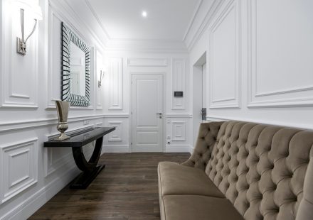Wit interieur met tufted bank en klassieke muurpanelen
