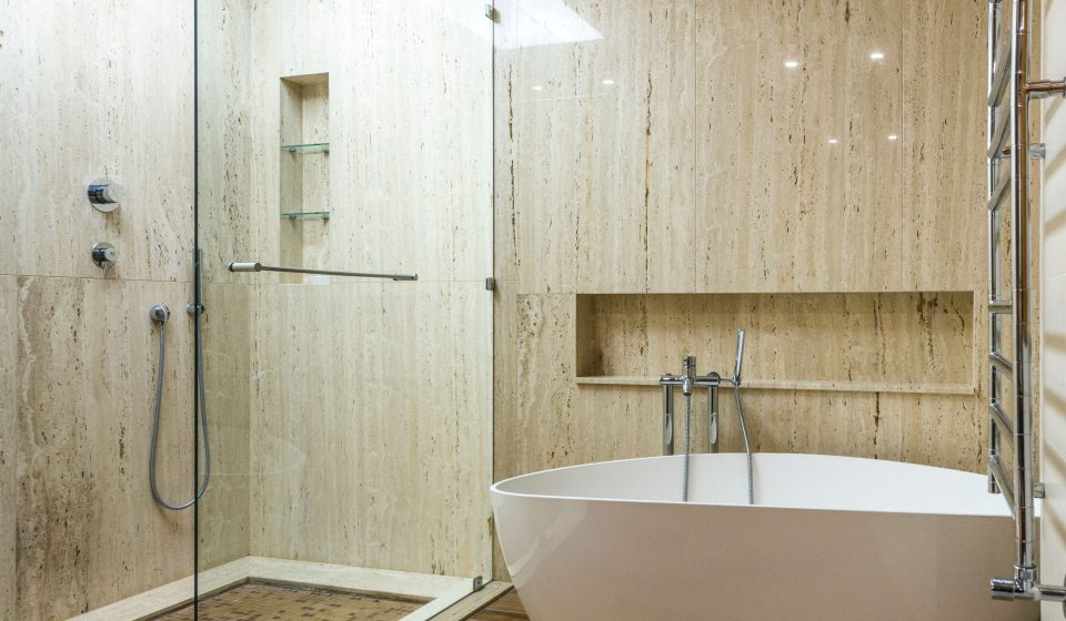 Moderne badkamer met marmeren muur, glazen douche en badkuip