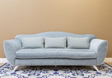 Blauwe bank met kussens op een patroon vloerkleed