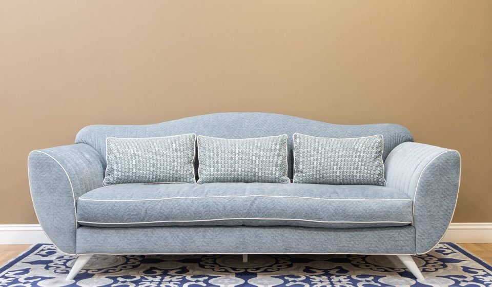 Blauwe bank met kussens op een patroon vloerkleed